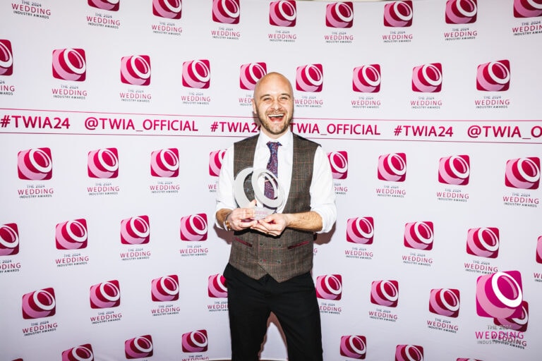Photograph of wedding videographer Roo Stain holding a trophy for winning the wedding industry award of best wedding videographer in the UK